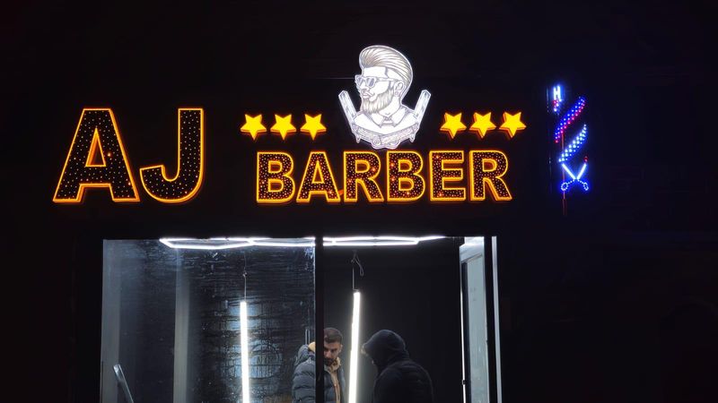 Custom LED neon sign for AJ Barber with a barber pole motif