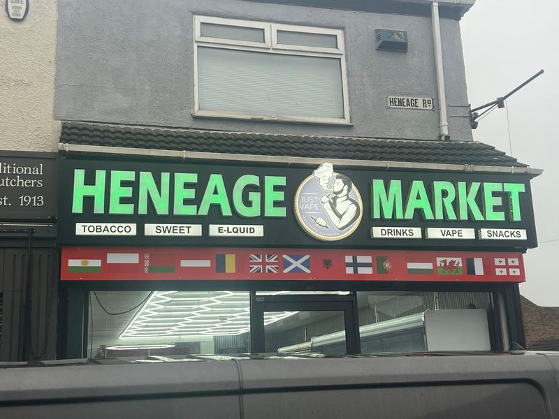 Colourful illuminated Heneage Market fascia with international flags
