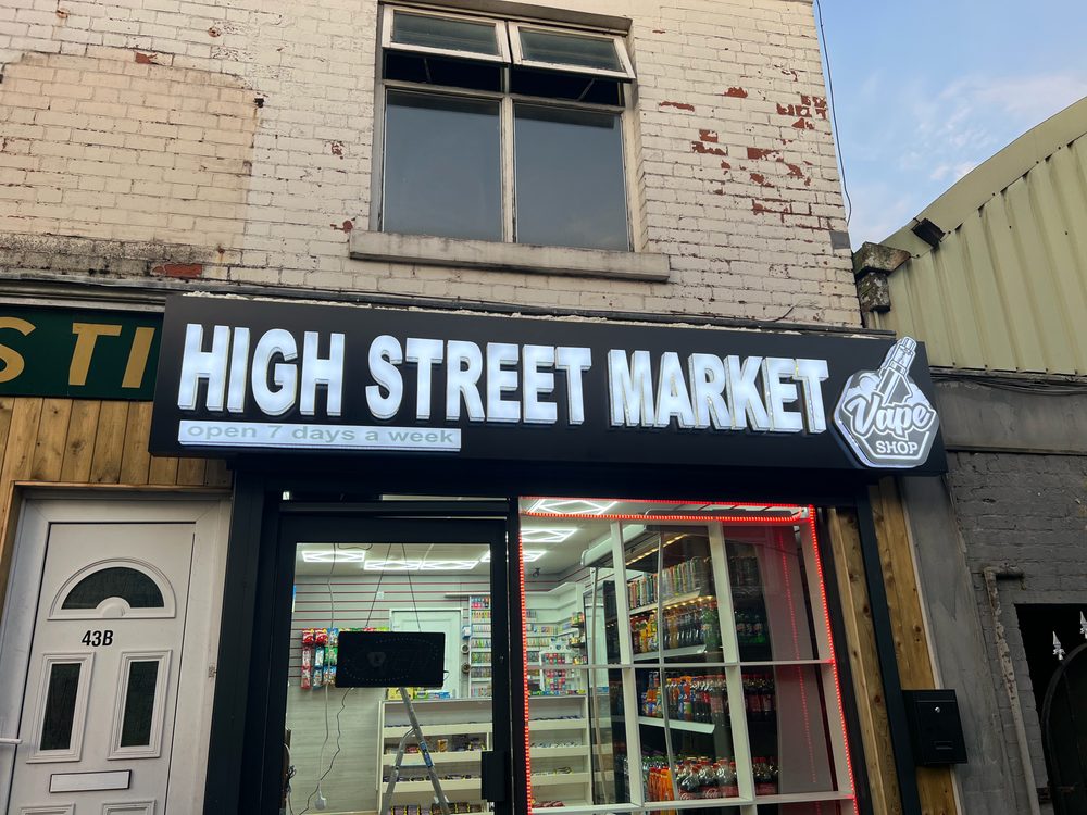 White illuminated fascia sign for High Street Market convenience store