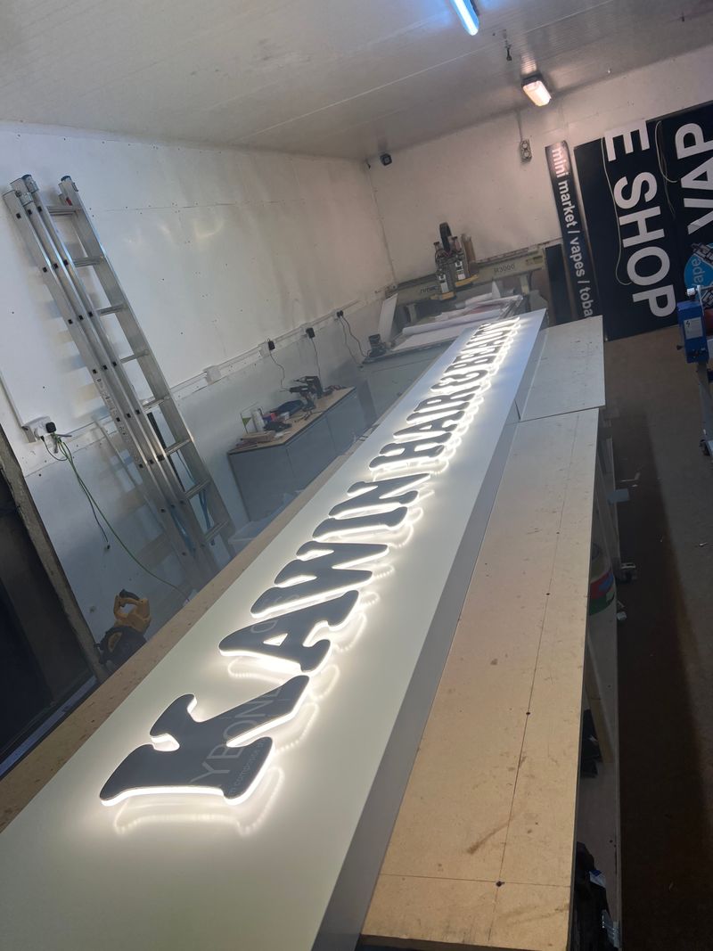 White illuminated built-up letters on a shop fascia