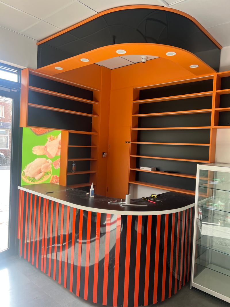 Bespoke retail counter and shelving shop fit-out in orange and black