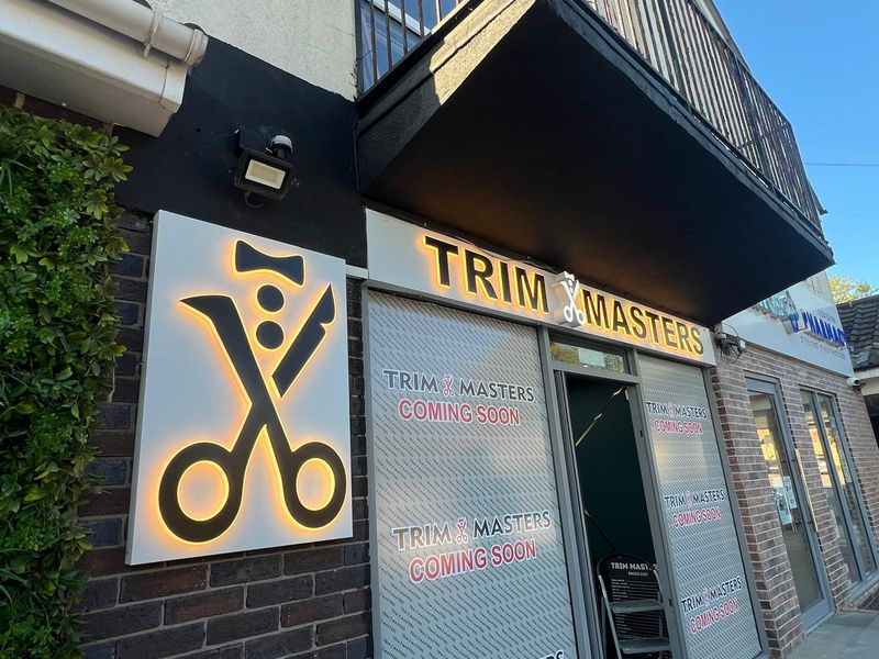 Illuminated Trim Masters barbers shopfront with scissors logo