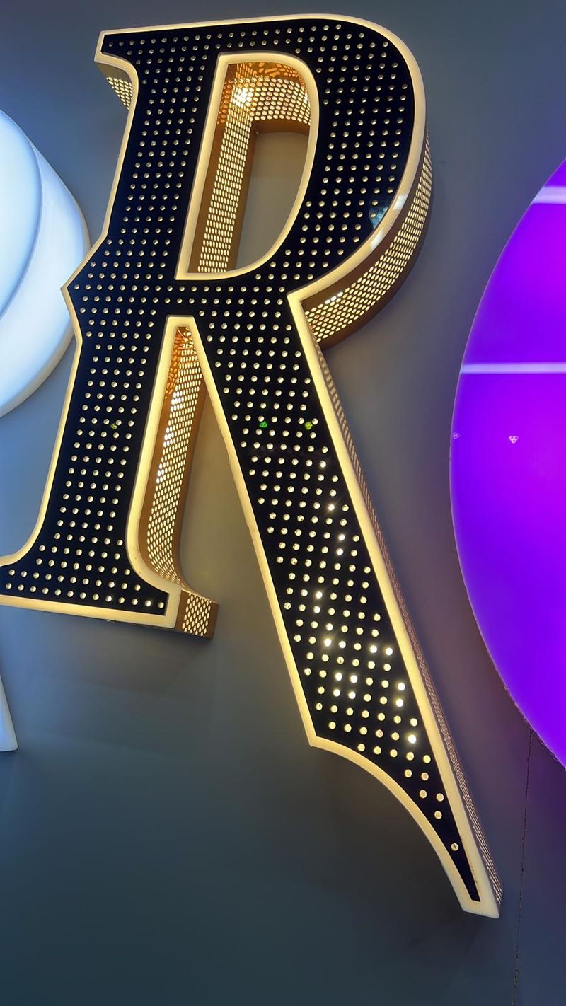 Vintage-style marquee letter R studded with warm bulbs